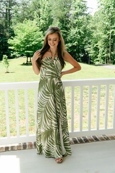 Product Details: Elevate your vacation style with our Cruising Along Satin Maxi Dress. This stunning dress features a green and cream palm leaf pattern, with a side skirt slit for added movement. The satin material and gold metal chest detail add a touch of luxury, while the adjustable halter neckline and smocked back ensure a perfect fit. Lightweight and breezy, this dress is perfect for your next getaway. Product Material: 100% Polyester Hope's Go-To Outfit: "I paired this stunning dress with Metal Chest, Palm Leaf Pattern, Palm Leaves Pattern, Satin Maxi, Private Island, Satin Maxi Dress, Vacation Style, Satin Material, Romper Dress