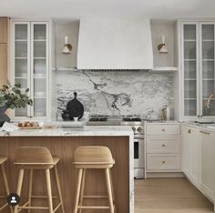 a kitchen with marble counter tops and wooden stools