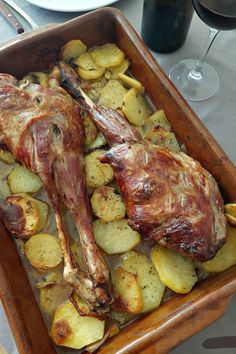 a roasting pan filled with meat and potatoes