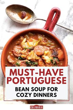 A red clay pot of hearty Portuguese bean soup loaded with sausage, vegetables, and beans, with a rustic spoon on the side.