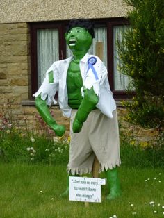 a statue of a man in shorts and a white shirt with a blue ribbon around his neck