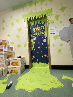 a room decorated in green and white with paper cut outs on the floor, cardboard boxes scattered around