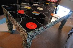 a table with vinyl records on it in the middle of a living room filled with furniture