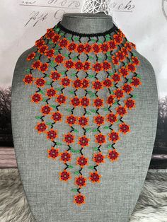 Beautiful necklace of flowers of chaquiras made by Mexican artisans.the necklace measures approximately 10.5 in the longest part.the necklace brings approximately 75 to 78 flowers. Orange Flower-shaped Beaded Necklaces, Bohemian Orange Flower Beaded Necklace, Handmade Red Flower Beaded Necklaces, Handmade Red Beaded Flower Necklaces, Colorful Flower Beaded Festival Necklace, Colorful Beads Flower Necklace For Festival, Colorful Beaded Flower Necklace For Festival, Unique Beaded Flower Necklace, Beaded Flower Necklace With Round Beads For Festivals