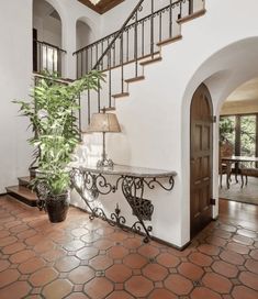 an entry way with a potted plant and stairs