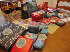 the table is covered with lots of wrapping paper and gift wrapped in different patterns, shapes and sizes