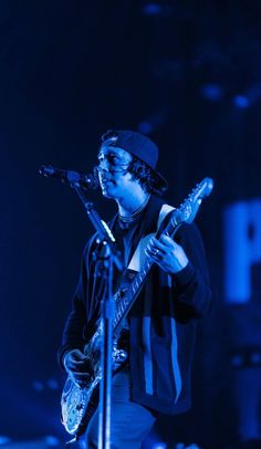 a man with a guitar on stage at a concert