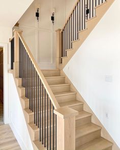 a staircase with black railing and white walls