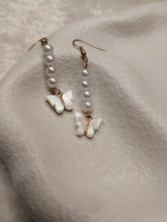 These stunning gold earrings with pearls and white butterfly charm will be your new favs! They are a great bridal party gift! Dainty White Pearl Earrings For Party, White Butterfly Charm Earrings As Gift, Dainty Butterfly Earrings For Wedding, Wedding Drop Earrings With Butterfly Charm, White Butterfly Charm Earrings For Wedding, Elegant White Butterfly Charm Earrings, Elegant White Earrings With Butterfly Charm, White Butterfly Charm Earrings, White Butterfly-shaped Earrings With Butterfly Charm