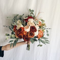 a person holding a bouquet of flowers on a white background in front of a wall