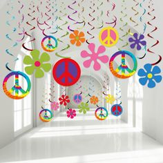 a room filled with lots of colorful decorations and hanging paper peace signs on the ceiling