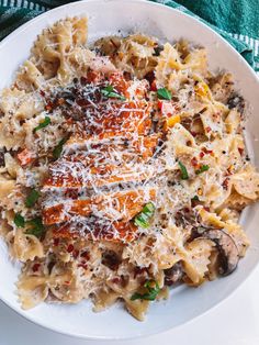 a white plate topped with pasta covered in sauce