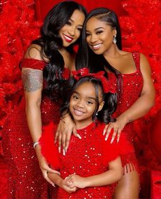 two women in red dresses posing for a photo with their arms around one woman's shoulders