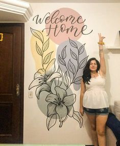 a woman standing in front of a welcome home sign