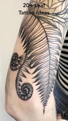 a black and white photo of a fern leaf tattoo