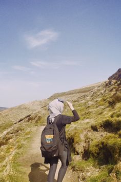 a person with a backpack walking up a hill