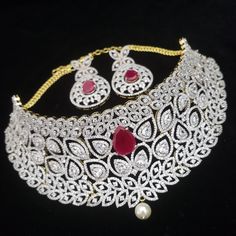 "Handmade Indian Jewelry, best to wear for traditional ceremonies or Indian wedding. This bridal jewelry has ethnic finish. It has very high quality ADs with ruby It is a Bollywood style one gram jewelry. Handmade Indian Jewelry item * Necklace Set is a combo of Necklace & Stud Earrings * Necklace is adjustable with adjustable back chain/ Dori/ Cord * Earring Length: 2\", Earring Width: 1.0\" * Choker : Main design 8 inches. Center 2.5 inches * Gold Color is gold tone which has a bright gold Traditional Ruby Jewelry Sets For Diwali, Heavy Diamond Bridal Necklace For Festivals, Round Ruby Jewelry With Tilla Details, Diwali Ruby Jewelry Set With Intricate Design, Traditional Ruby Jewelry Sets With Intricate Design, Silver Ruby Jewelry Sets For Festivals, Ceremonial Diamond Bridal Necklace With Intricate Design, Traditional Red Diamond Bridal Necklace, Festive Heavy Cubic Zirconia Necklace