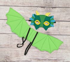 a green umbrella with a dragon mask on top of it next to a paper cutout