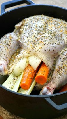 a chicken in a pot with carrots and celery