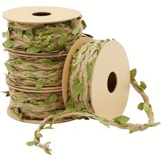 three spools of twine with green leaves on them are sitting next to each other