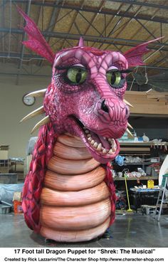 a pink dragon statue sitting on top of a table