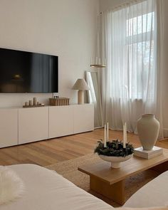 a living room filled with furniture and a flat screen tv mounted to the side of a wall