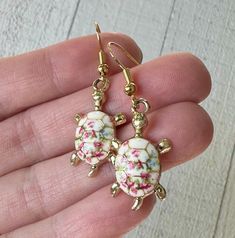 We are happy to introduce our handmade Floral Turtle Earring Collection!  These miniature turtles are absolutely adorable and are available in three colorful flower variations: Light pink, dark pink and blue.  Collect them all and mix and match!  Our Hawaiian inspired floral turtle earrings are lightweight and dainty - ideal for everyday wear.  We've paired them with 14 karat gold hooks for a truly elegant look and feel.  If you know a turtle lover, these delicate floral earrings would be the pe Casual Handmade Flower Earrings For Gift, Multicolor Hypoallergenic Flower Earrings Gift, Cute Multicolor Handmade Flower Earrings, Cute Handmade Multicolor Flower Earrings, Handmade Cute Multicolor Flower Earrings, Pink Flower Earrings For Beach, Delicate Pink Flower Charm Earrings, Cartiloge Earring Turtle, Cheap Tortoise-colored Jewelry Gift