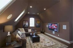 a living room filled with furniture and a flat screen tv mounted to the side of a wall