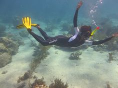 a woman is swimming in the ocean with her scuba gear