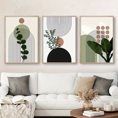 three abstract paintings hang on the wall above a white couch in a living room with a coffee table