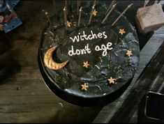 a black cake with gold stars and the words witches don't age written on it