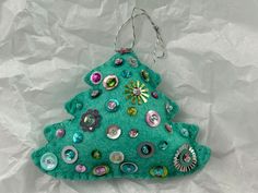 a green christmas tree ornament with buttons on it