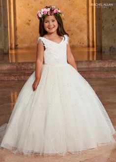 Your sweet girl will light up the room in this beaded fringe long sleeve dress with A-line glitter tulle skirt by Rachel Allan RB9140. This glitter tulle ballgown is the perfect choice for any flower girl's special day! Featuring a classic V-neckline and an embellished bodice and waistline, this elegant dress is sure to make your young one feel every inch as special as a princess. With a secure lace-up back and a sweeping train, this dress is designed to make her look and feel like royalty. Ador Girls First Communion Dresses, Tulle Ballgown, Mary's Bridal, Sleeve Gown, First Communion Dresses, Dresses Quinceanera, Girls Formal Dresses, Rachel Allan, Communion Dresses