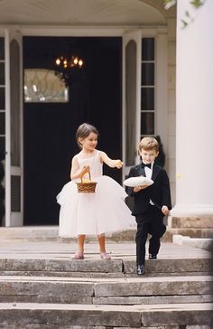 two young children dressed in tuxedos are walking down the steps