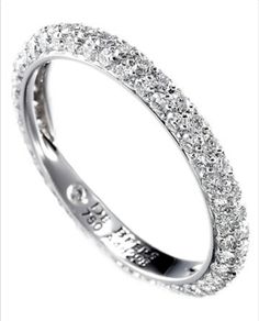 a white gold wedding ring with rows of diamonds on the sides and an inscription that reads,