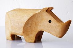 a wooden toy elephant on a white surface