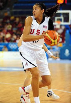 a women who is holding a basketball in her hand and dribbling it with the ball