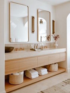 a bathroom with two sinks, mirrors and towels on the counter top next to each other