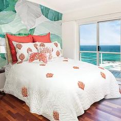 a bed sitting next to a window in a bedroom near a wooden floor and white walls