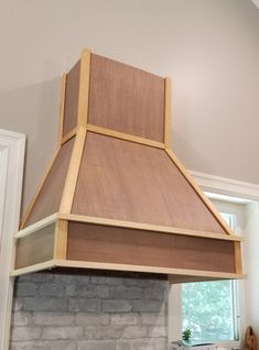 a stove top oven sitting inside of a kitchen next to a wall mounted oven hood