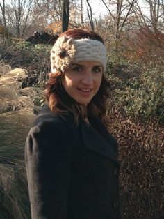 a woman wearing a crocheted headband in the woods