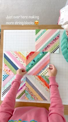 a girl is working on a quilt using scissors and fabric scraps in front of her