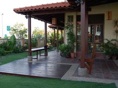 a wooden bench sitting in the middle of a lush green yard next to a building