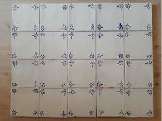 several blue and white tiles on a wooden surface