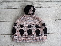 a knitted hat sitting on top of a wooden floor next to a white wall