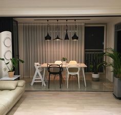 a living room with a couch, table and chairs next to a wall mounted plant