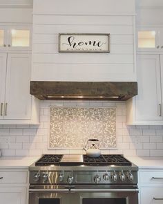 a stove top oven sitting inside of a kitchen next to white cabinets and counter tops