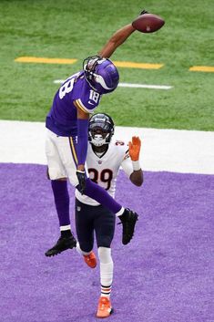 two football players jumping up in the air