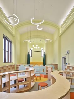 the interior of a library with tables, chairs and lights hanging from the ceiling above