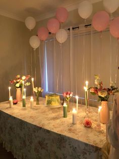 a table topped with lots of candles and balloons